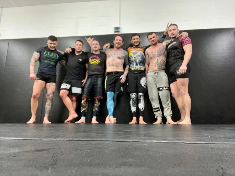 Students practise a grappling position during a training session.
