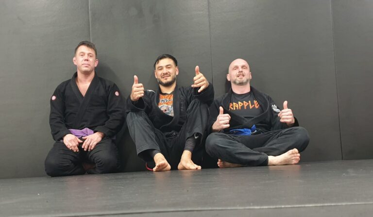 Training partners work through a jiu-jitsu drill on the mat.