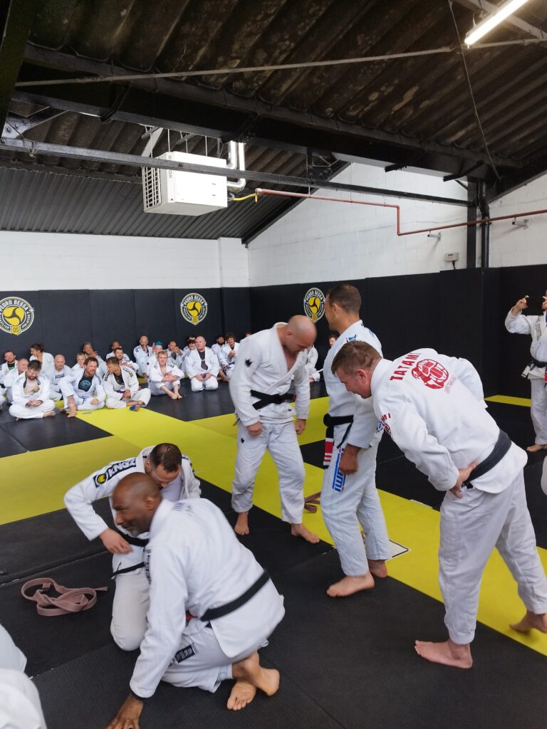 A coach leads students through a Brazilian jiu-jitsu drill.