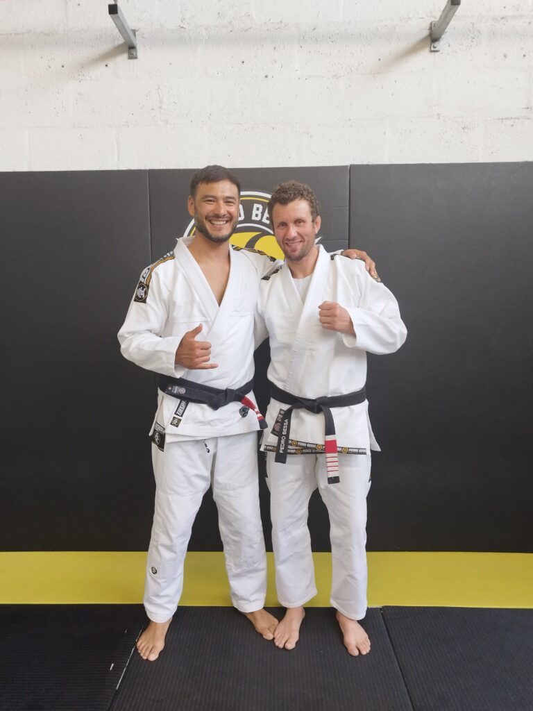 Two adult students in gis at a Kaizen BJJ training event.