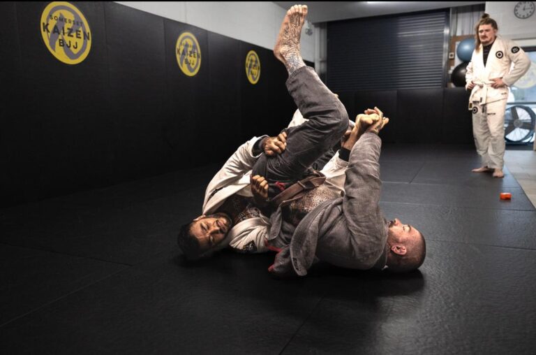 Two students practise ground grappling in the training room.