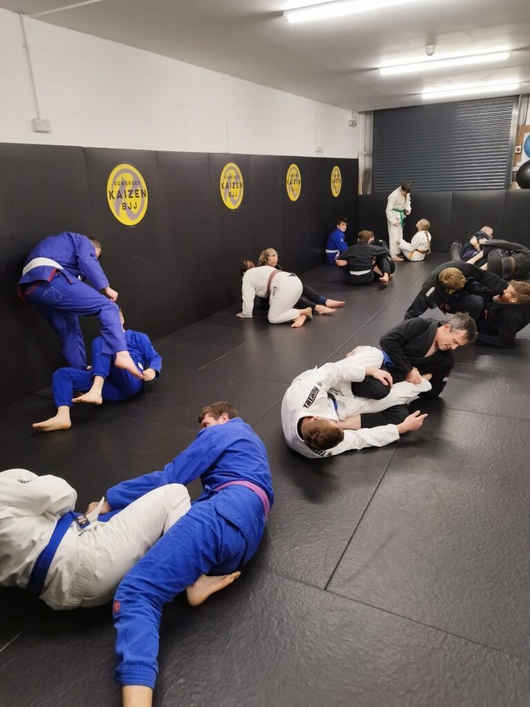 Students practise Brazilian jiu-jitsu drills across the Kaizen BJJ mats.