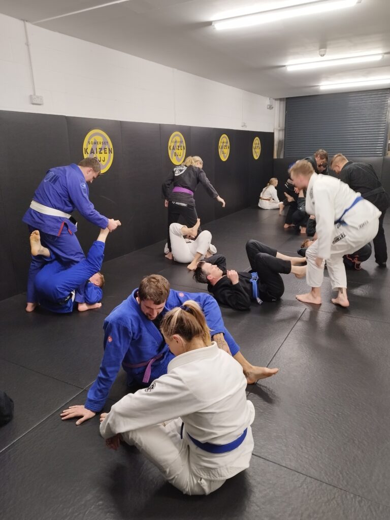Students practise grappling techniques during a busy Brazilian jiu-jitsu class.